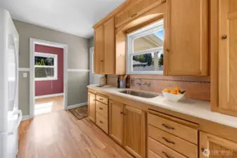 The simple kitchen style has ample cabinets and flows into the dining area.