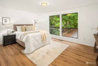 The primary bedroom has large windows to the front of the house, a wall of closets and an ensuite bathroom.