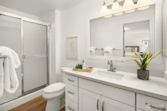 The Primary Bedroom Bath has a new cabinet, quartz counter, sink, faucet, mirror and lighting.