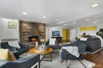 Lower level recreation room and additional seating area, with stone fireplace and hardwood floors