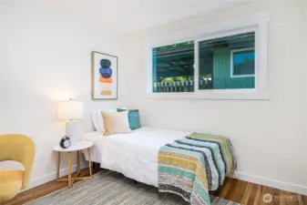 "Third bedroom on the main level with a south-facing window. Just out of frame on the left is a cozy nook, ideal for a desk and chair.