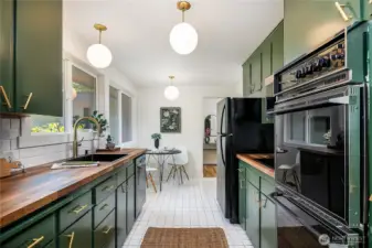 Bright and beautiful kitchen with tons of natural light and eye-catching midcentury-style lighting that adds a swanky touch.
