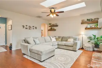 Living room with engineered hardwood floors and skylights