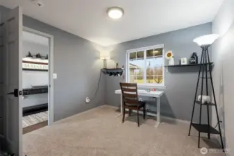 Bedroom #1 used as an office, with front yard view; closet is located behind the photo.