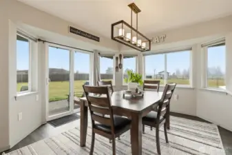 Wonderful dining space with wide bay windows and modern fixture.  The home has been outfitted with pull down shades that offer insulation and room darkening when desired.  The privacy of the property means they are rarely needed!
