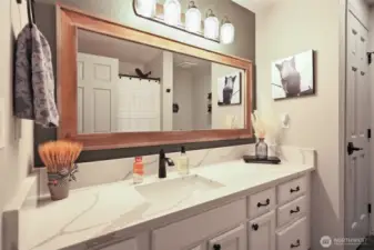 Hall bath continues the beautiful quartz counters, and offers linen storage and tub/shower combo.