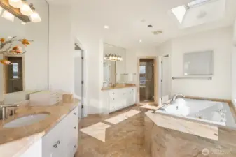 Timeless elegance defined by extensive marble flooring, custom stone counters, and a matching bath surround.