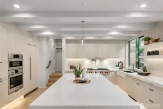 Gourmet Kitchen: Cook and entertain in style with a gourmet kitchen featuring a stunning waterfall quartz countertop and built-in refrigerator.