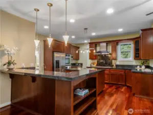 The well appointed kitchen features stainless steel appliances including a gas range with pot filler & double oven, beautiful cabinetry, granite countertops, walk-in pantry, breakfast bar & eating nook with bay window.
