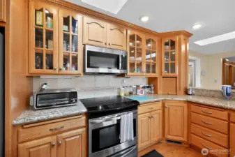 The large kitchen offers oak cabinetry, granite countertops, a roomy pantry, and a breakfast bar for casual dining