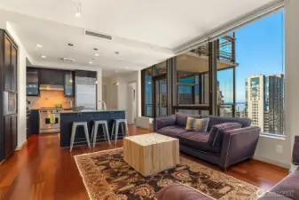 Huge window walls frame this open living layout with city and Sound views.
