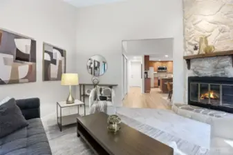 The cozy living room with a wood burning fireplace and soaring ceilings.