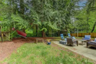 Backyard features an entertainment-sized deck for parties and BBQ's, a large fenced yard with a fire pit, swing set!