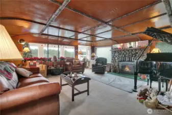 Spacious living room showcasing a stone gas fireplace with water view.
