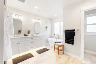Primary bath has a separate toilet room, tiled, a free standing tub under a frosted glass window, double sink vanity with under cabinet lighting!