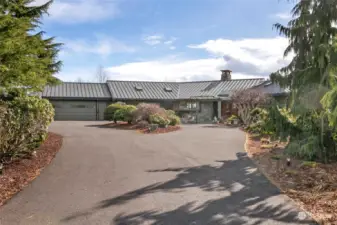 Large asphalt circular driveway with extra parking.