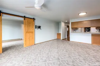 Living/dining room looking towards primary bedroom with barn doors.
