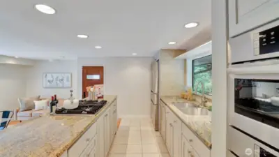 This well-appointed kitchen boasts granite counters, premium appliances, and a spacious island with gas cooktop.