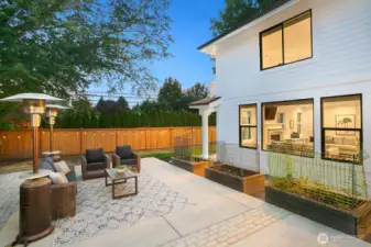 The patio is surrounded by the swim spa (to the left here) and garden beds all around.