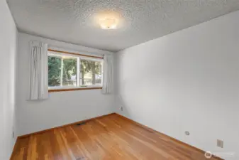 Main floor bedroom with original wood flooring