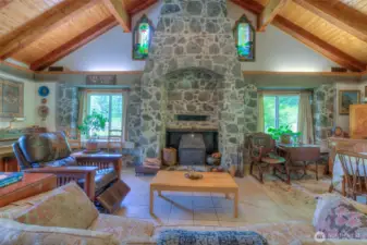 Massive stone wood burning fireplace is the center piece of the living room with vaulted ceilings.