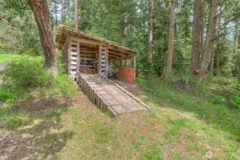 Wood storage shed also made to house a tractor or lawn mower.