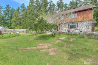 An outdoor person’s paradise with trees, shrubs, plantings and garden areas.