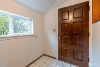 A solid wood door welcomes you in. The floor is tile for easy cleaning.
