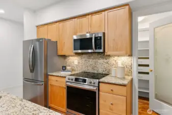 Kitchen with all new stainless steel appliances. Huge pantry to the right.