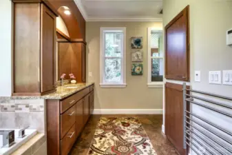 Another view of primary bath with plenty of storage, towel racks.