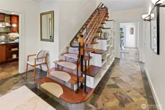 Custom built stairwell with custom iron work detail. Entry to hallway and dining room. Kitchen on the left