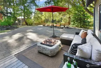 Patio features fireplace and seating area. Raised beds for vegetable growing in the background