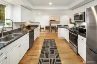 The updated kitchen! Definitely room for all of the cooks here. Stainless appliances and lots of cabinet space. You can see the large dining space at the other end of the kitchen.