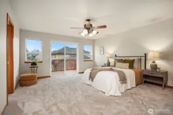 The primary suite is just up the short run of stairs and overlooks the rear yard and also opens to the expansive south-facing deck.