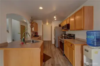 Back in the well designed kitchen. Looking down the kitchen, you'll see the pantry on the left and half-bath waaay down on the right. Looking at the hallway, you can see the coat closet and stairs to the upper floor.