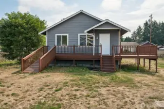 This is the straight-on shot that sells it. Covered entry so you’re not juggling keys in the rain, a natural spot for seating, and a ramp that looks designed, not tacked on. The gray exterior with cedar decks nails that Pacific Northwest look, and it’s basically a blank canvas for your holiday moment.