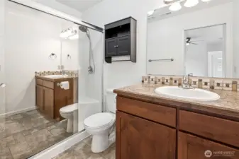In the primary bath you’ll find a mirrored shower door that makes the space brighter, a shower with a handheld showerhead option, built-in seat, and waterproof vinyl stone design flooring that doesn’t mind daily use. The wide shaker vanity with an easy-care Formica top offers storage for everything you don’t want on display.