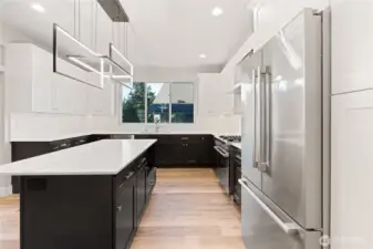 Huge kitchen, lots of cabinets and countertop space, big kitchen island with eat-in space, premium finishes, custom light fixtures, quartz counters.