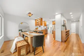 Seamless open-concept flow connects dining and kitchen, designed for elevated gatherings and effortless hosting. Warm wood cabinetry, quartz surfaces, and clean architectural lines create a polished, move-in-ready presentation.