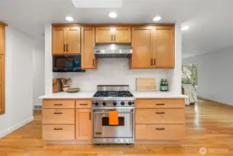 Professional-grade Viking gas range with commercial hood anchors this chef-caliber kitchen. A striking herringbone tile backsplash, custom cabinetry, and quartz counters elevate both design presence and culinary performance