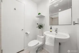 Main bathroom featuring a full tile surround and tub, offering durability and timeless appeal. A dedicated linen closet adds valuable storage while clean, neutral finishes create a polished and functional space.