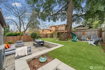 Thoughtfully tiered landscaping offers seamless flow between dining, lounging, and open green space. Clean architectural lines and perimeter fencing provide privacy while maintaining an expansive feel.