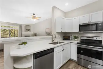 Quartz countertops provide generous prep space along with convenient bar seating for casual dining or conversation.