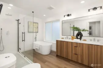 primary bathroom with custom cabinetry, quartz countertops, soaking tub & large shower