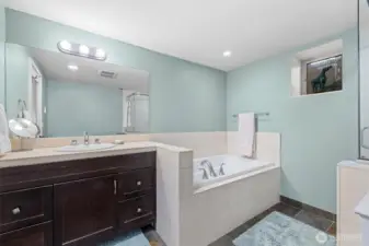 Primary bathroom with soaking tub, surrounded by travertine tiles on exposed surfaces.
