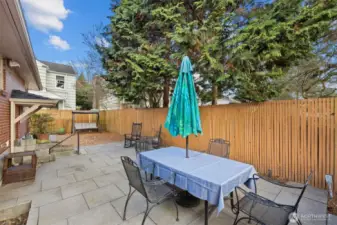 The patio is large enough for a big table to entertain. At night lights illuminate the area along the fence.