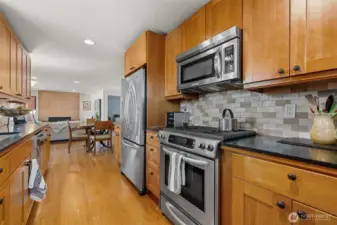 The kitchen from the east wall. Gas stove, French door fridge, efficient layout and recessed lighting to illuminate food preparation.