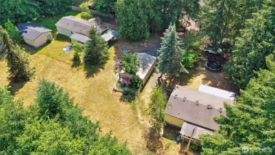 Two double-wide manufactured homes sit on the west side of the property, as well as a carport (center photo) and large barn/shed (left photo).