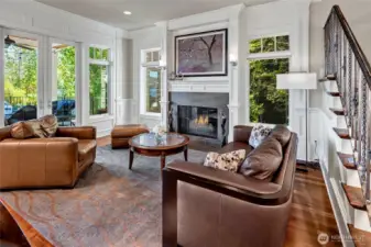 The living room is anchored by one of 4 gas fireplaces throughout the home, with another set of French doors leading to the south side of the deck.