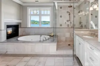 The two-sided fireplace above the bathtub completes this spa-like primary suite.
